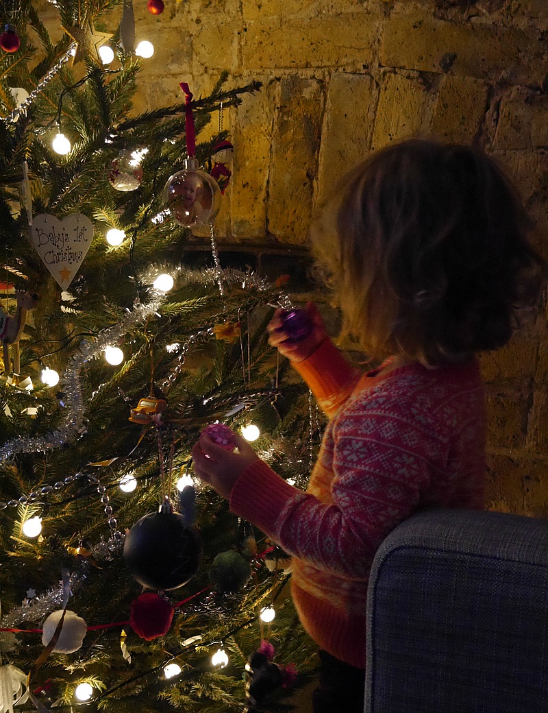 toddler decorating a christmas tree
